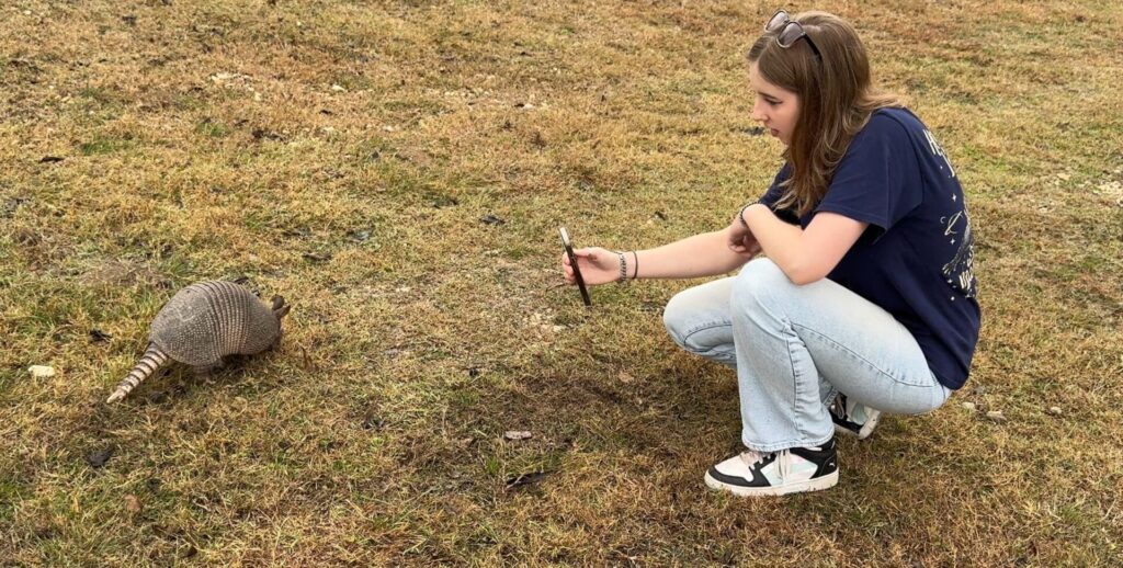 Armadillo approaches my daughter as she takes its photo